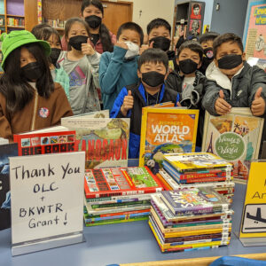 A group of children with donated books at the Franklin Library in Oakland, California